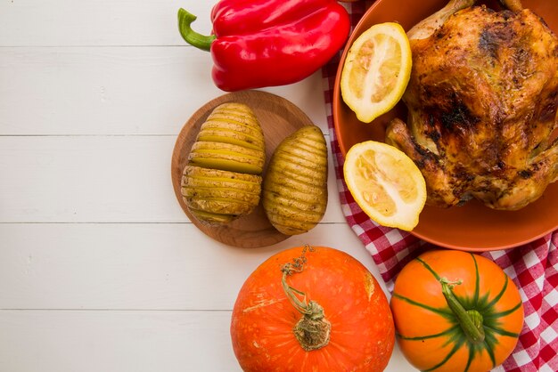 Pollo al horno con patatas en la mesa