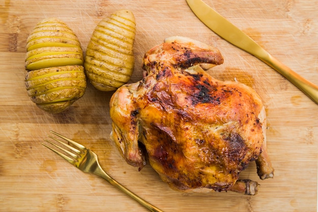 Pollo al horno con patatas en la mesa