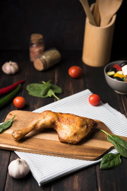 Pollo de alto ángulo sobre tabla de madera con ingredientes