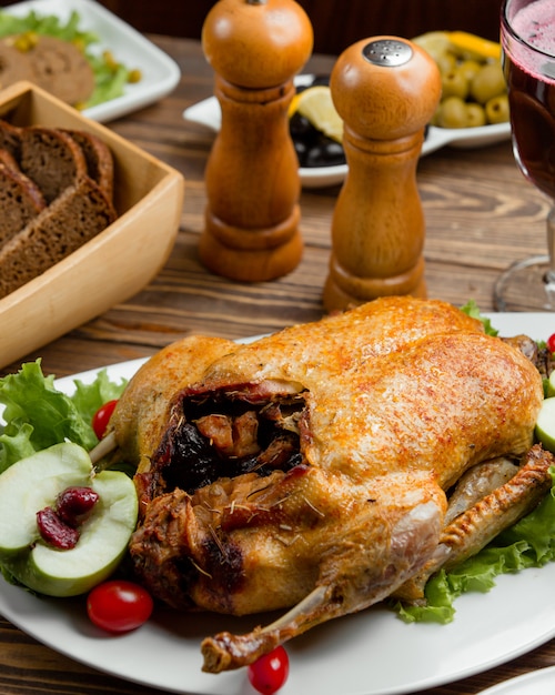 Foto gratuita pollo asado entero relleno con pan y vino tinto