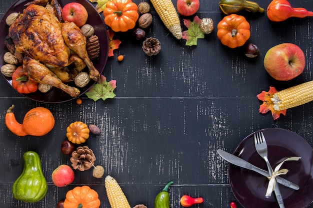 Pollo asado junto a verduras, frutas y plato.