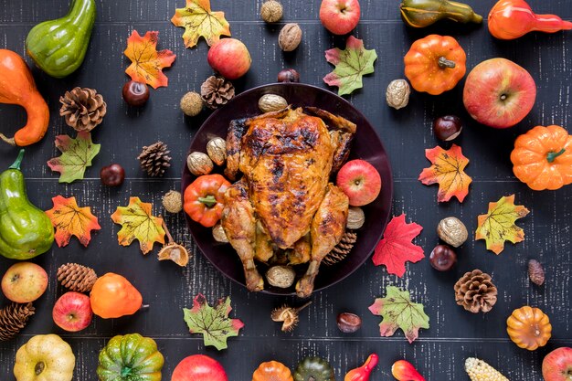 Pollo asado entre verduras y frutas.