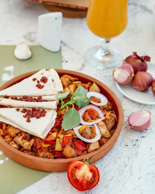 Pollo asado y verduras en una sartén de cerámica