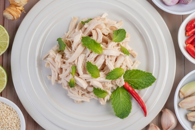 Foto gratuita el pollo bordeado se cocina y se coloca en un plato blanco junto con hojas de menta.