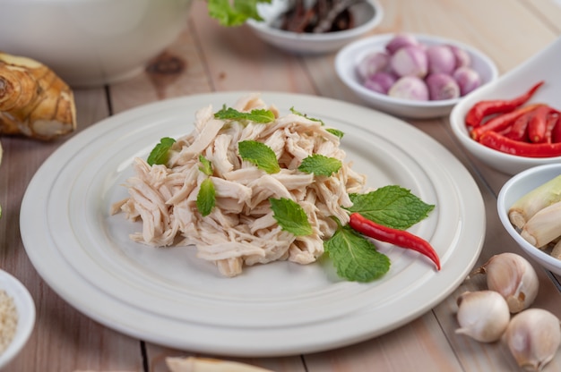 El pollo bordeado se cocina y se coloca en un plato blanco junto con hojas de menta.