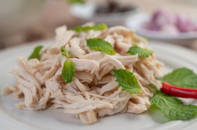 El pollo bordeado se cocina y se coloca en un plato blanco junto con hojas de menta.