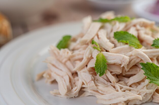 El pollo bordeado se cocina y se coloca en un plato blanco junto con hojas de menta.