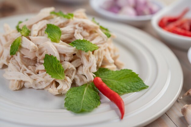 El pollo bordeado se cocina y se coloca en un plato blanco junto con hojas de menta.