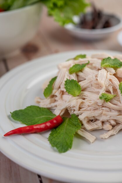 El pollo bordeado se cocina y se coloca en un plato blanco junto con hojas de menta.