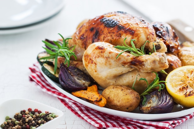 Pollo cocinado al horno con limón y verduras en un plato