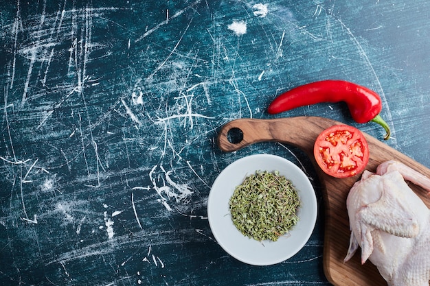 Foto gratuita pollo crudo con hierbas y verduras.