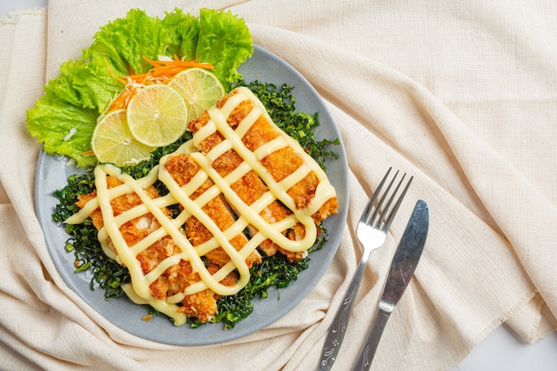 Pollo crujiente con crema de limón, bellamente decorado.