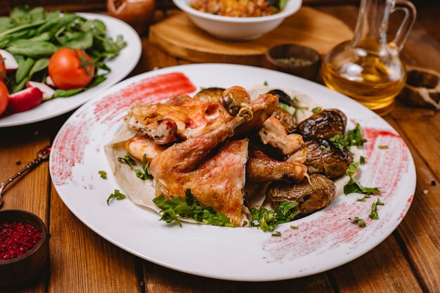 Pollo entero a la parrilla servido con papas a la parrilla