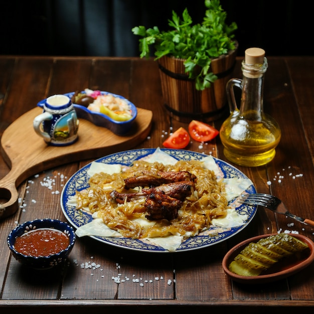 Pollo frito con cebolla en la mesa