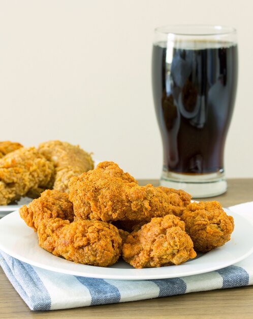 Pollo frito con cola en la mesa de comedor