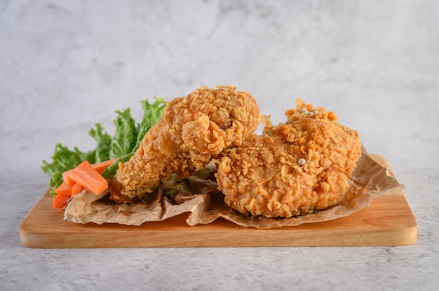 Pollo frito crujiente sobre una tabla para cortar madera