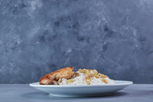 Pollo frito con guarnición de arroz.