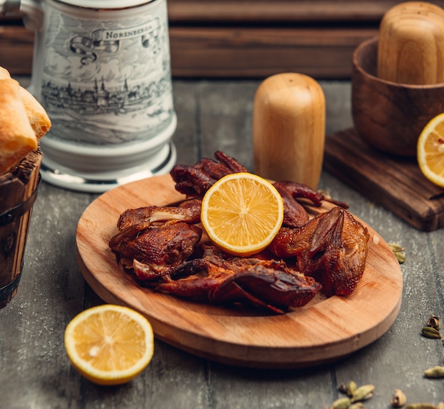 pollo frito con limón sobre la plancha de madera