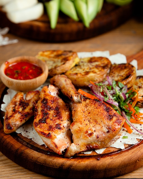 Foto gratuita pollo frito con papas sobre la mesa