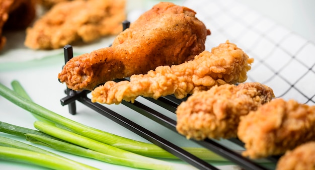 Pollo frito de primer plano en bandeja con cebollas verdes