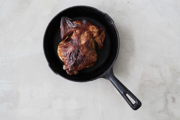 Pollo frito en sartén negra