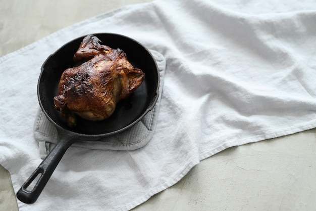 Pollo frito en sartén negra