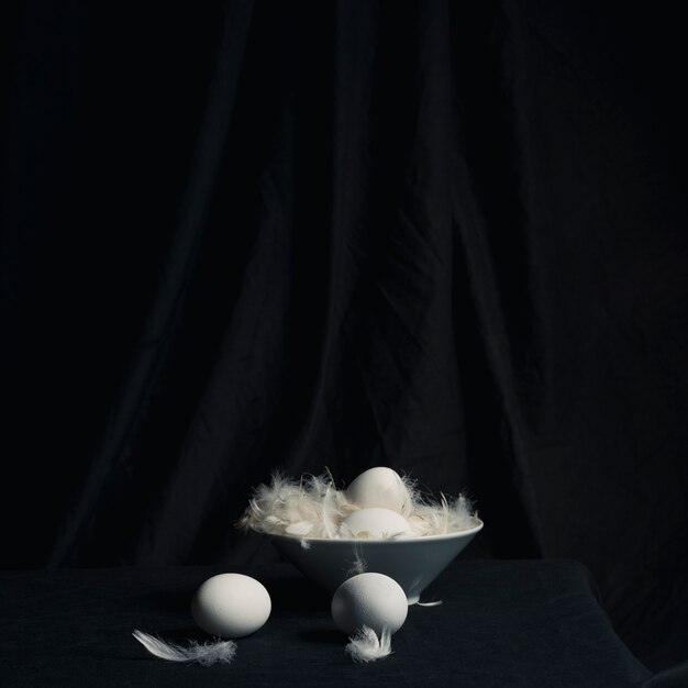 Pollo huevos entre plumas en un tazón