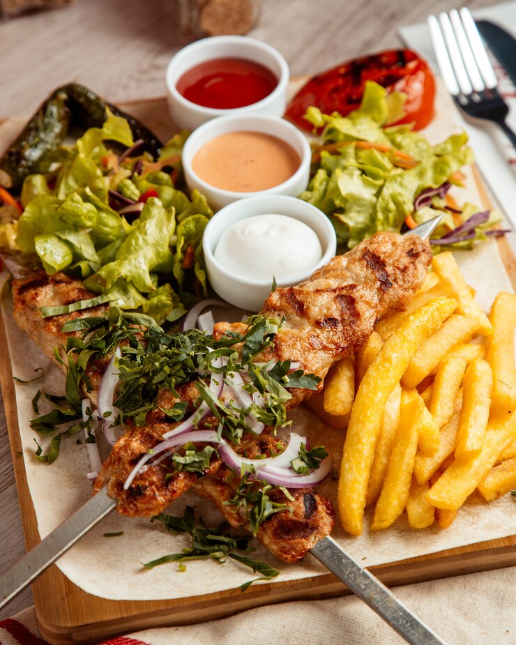 Foto gratuito pollo lula papas fritas ensalada vista lateral