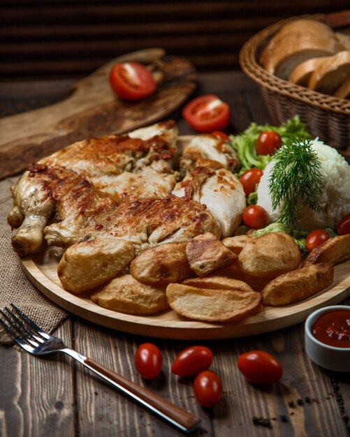 Pollo a la parrilla y papas con arroz, bayas, eneldo y tomate.