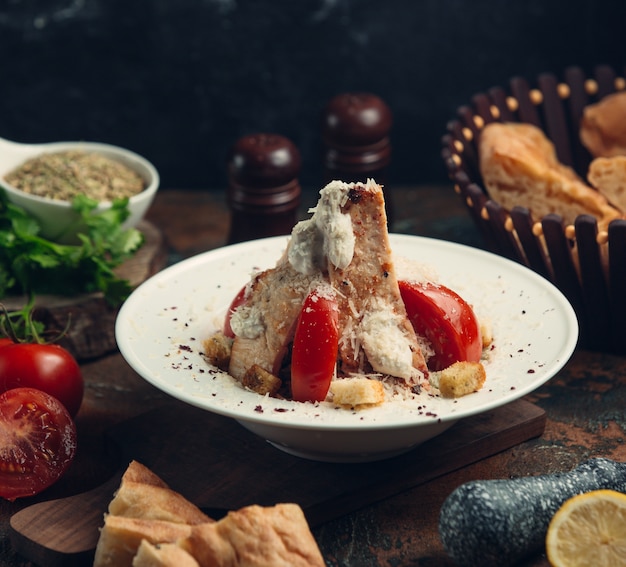 Pollo a la parrilla con queso mozarella y tomates.