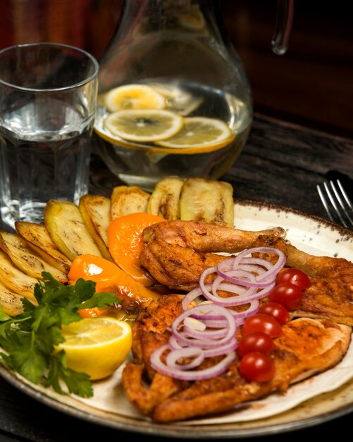 Pollo a la parrilla servido con berenjena, limón, perejil y