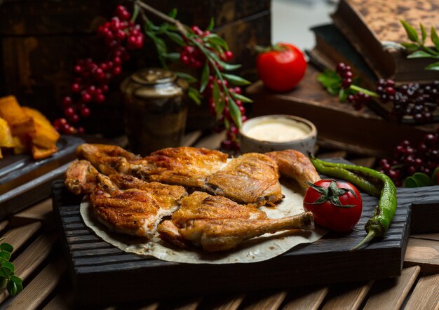 Pollo a la parrilla servido en lavash con pimiento asado y tomates