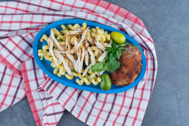 Pollo y pasta a la parrilla en placa azul.