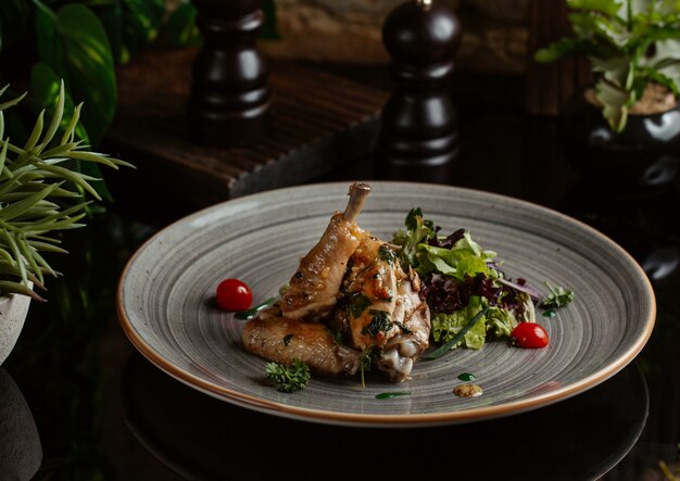 Pollo salteado en plato de cerámica azul con ensalada