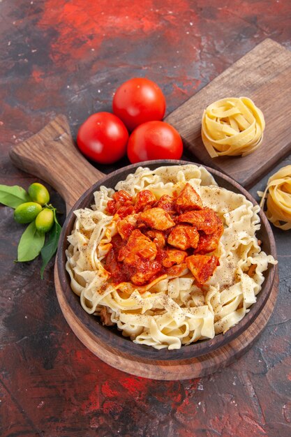 Pollo de vista superior con plato de pasta de masa con tomates en la comida de masa de pasta de escritorio oscuro