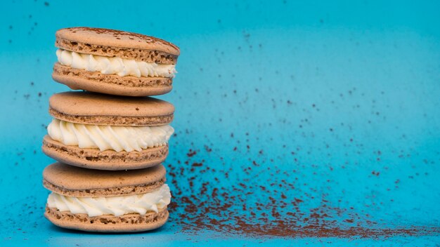 Polvo de chocolate con macarrones sobre fondo azul