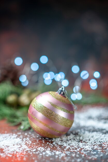 Polvo de coco de bola de árbol de Navidad de vista frontal en luces de Navidad oscuras