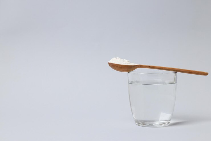 Foto gratuito polvo de colágeno en una cuchara de madera con un vaso de agua