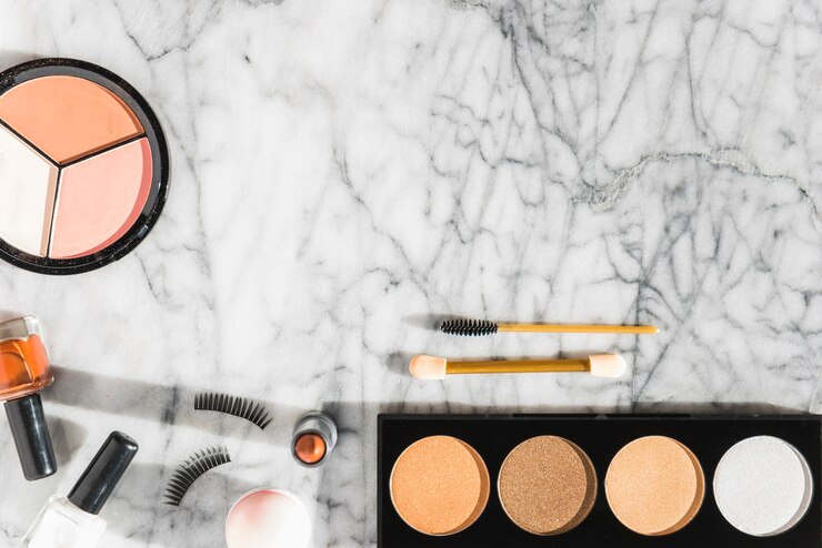 Foto gratuito polvo compacto; esmalte de uñas; lápiz labial; pestañas; rímel sobre fondo de mármol con textura