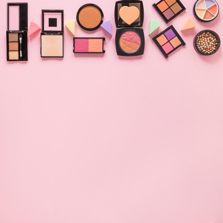Foto gratuito polvos faciales con sombras de ojos en mesa rosa.