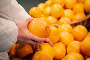 Foto gratuita pomelo en manos femeninas comprando frutas en un supermercado