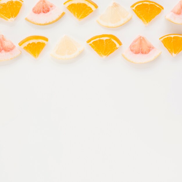 Pomelo triangular; Rodaja de naranja y limón sobre fondo blanco