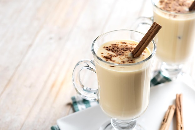 Foto gratuita ponche de huevo casero con canela sobre mesa de madera postre típico de navidad cerrar