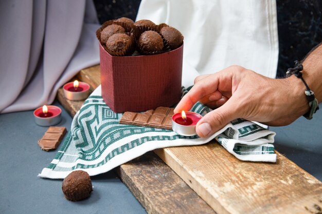 Poner velas encendidas alrededor de una caja de chocolate en el pedazo de madera