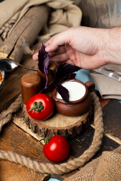 Poniendo tomates, yogur y hojas rojas de albahaca juntas.