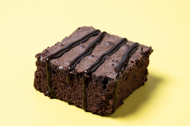 Foto gratuita porción de brownie de chocolate sobre fondo amarillo