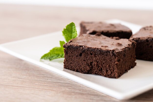 Porción de brownie de chocolate sobre mesa de madera