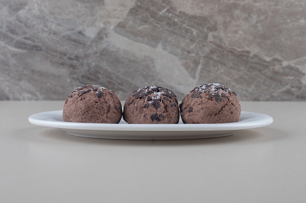 Foto gratuita porción de galletas de chocolate en un plato sobre fondo de mármol.