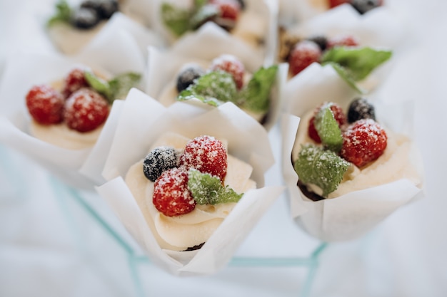 Porciones de postres decorados con crema y bayas