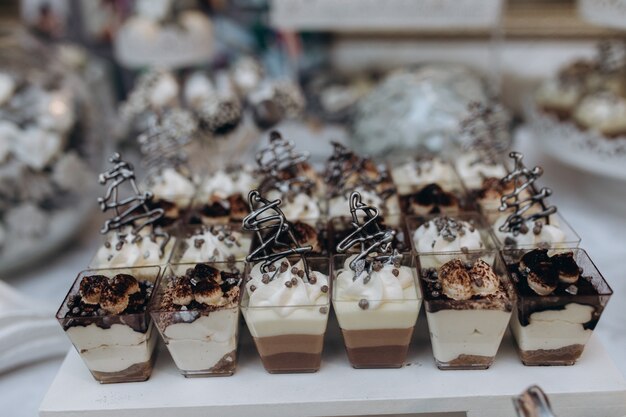 Porciones de tiramisú y postres de mousse se colocan sobre la mesa de catering